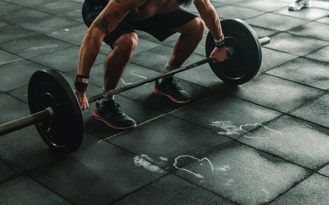 Man som styrketränar på gymmet