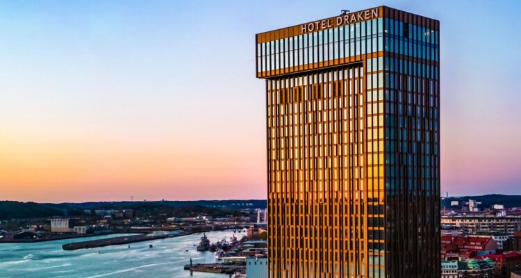 Clarion Hotel Draken i Göteborg – det 34 våningar höga glastornet med Hotel Draken-skylten i solnedgång, med Göta älv i bakgrunden