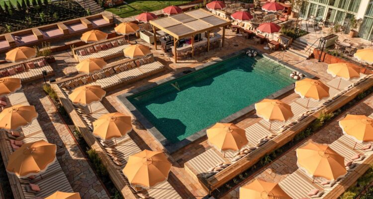 Utomhuspool med solsängar och orange parasoll vid Pool Club på Hjortviken Country Club i Hindås