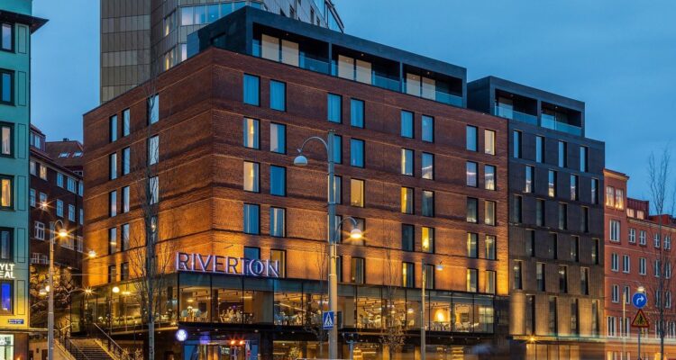 Hotel Riverton i Göteborg – tegelfasaden med Riverton-skylten vid Skeppsbron i kvällsljus