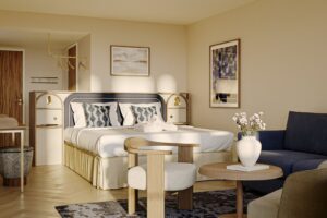 Ljust hotellrum med dubbelsäng, fåtölj och soffa på Kusthotellet Styrsö