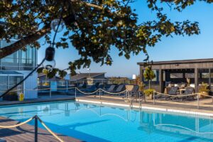 Utomhuspool med solsängar och bastuhus på spaterrassen på Torekov Hotell på Bjärehalvön