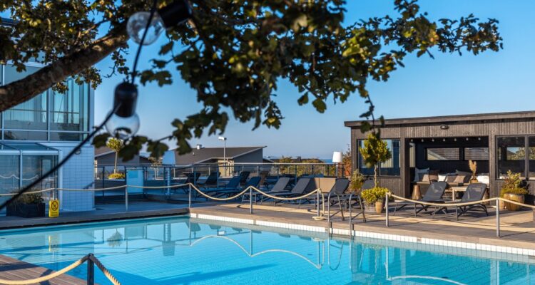 Utomhuspool med solsängar och bastuhus på spaterrassen på Torekov Hotell på Bjärehalvön